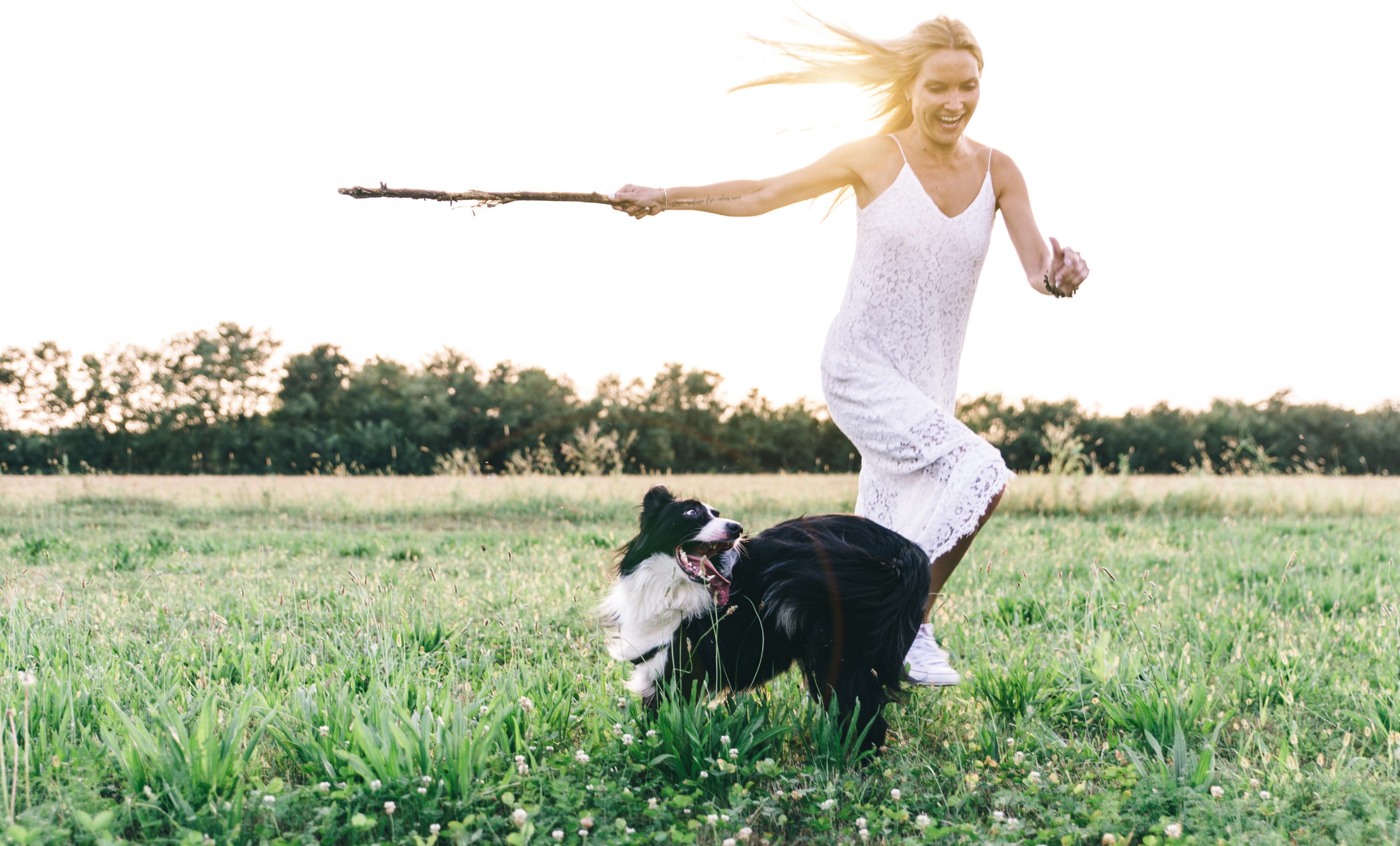 Blonde woman playing with border collie